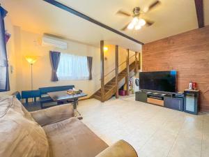 a living room with a couch and a flat screen tv at B&B 4 Rooms in Naha