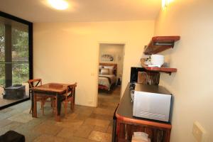 a kitchen and dining room with a table and a room with a bed at Down to Earth Farm Retreat in Sarsfield