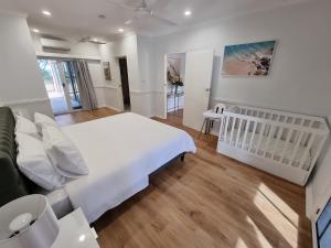 Ένα ή περισσότερα κρεβάτια σε δωμάτιο στο Willow Garden Stays Cairns - Beachfront 4 Bedroom Luxury Holiday Home +31 φωτογραφίες
