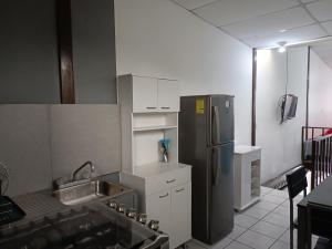 a kitchen with a stainless steel refrigerator and white cabinets at Pinares de Tecla in Nueva San Salvador