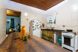 a kitchen with a wooden table and a refrigerator at Hostel Gentileza - Guest House in Alto Paraíso de Goiás