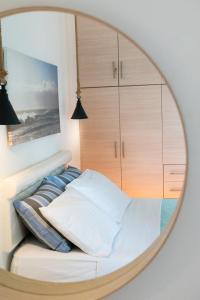 a mirror over a bed in a bedroom at Sagma calm apartment with amazing sea view in Perissa