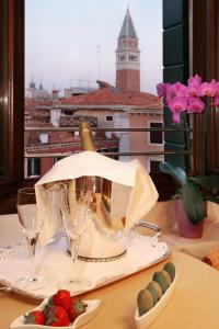 a table with wine glasses and a plate of strawberries at Residence Corte Grimani in Venice