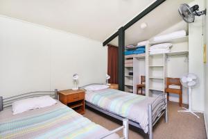 um quarto com 2 camas e uma secretária em Ngungun St 14 Dicky Beach em Caloundra