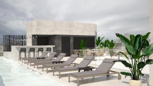 a row of chaise lounge chairs on a roof at M. HOTEL in San Antonio