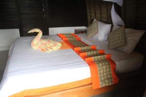 Una cama grande con una decoración de cisne. en Amed Paradise Warung & House Bali, en Amed