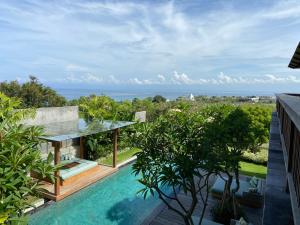 a house with a pool and a view of the ocean at Villa Biarritz in Uluwatu
