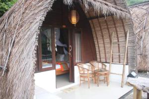 Cabaña pequeña con 2 sillas y mesa en Amed Paradise Warung & House Bali, en Amed