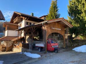 a small red truck parked outside of a building at Gartenwohnung im Gut Sonnenwald in Schöllnach