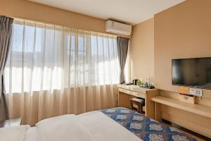 a hotel room with a bed and a television at Demei Boutique Hotel in Kunming