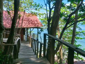 a wooden walkway leading to a resort on the beach at Jungle Hill Beach Bungalow in Ko Jum