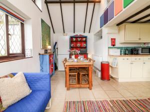 a kitchen with a blue couch and a table at Poppy Cottage in Tiverton
