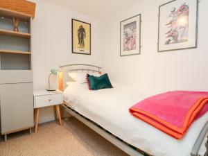 a small bedroom with a bed and a nightstand with a bed sidx sidx sidx at Poppy Cottage in Tiverton