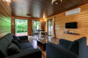 a living room with blue couches and a table at StayVista at Wooden House with Jacuzzi in Wada
