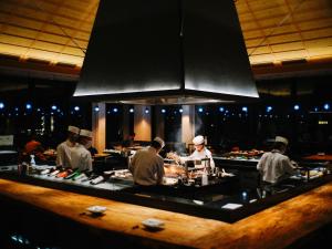 people are cooking in a restaurant kitchen at Hyatt Regency Seragaki Island Okinawa in Onna