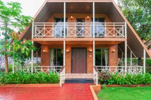 a house with a balcony and a red brick driveway at StayVista at Wooden House with Jacuzzi in Wada
