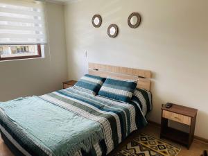 a bedroom with a bed with two clocks on the wall at Hermoso Departamento ubicado a 1 cuadra del lago Villarrica in Villarrica +14 photos