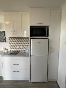 a kitchen with a refrigerator and a microwave at Self Contained Cabin in Nildottie