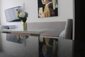 un tavolo con un vaso di fiori e uno specchio di Apartamento a 15 min de BUENAVISTA cerca a UNINORTE y CLINICA PORTOAZUL AA 2TV y parqueadero incluido a Barranquilla