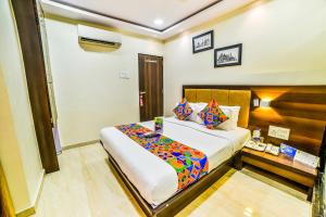 a bedroom with a large bed and a table at FabHotel Ascot International II in Mumbai