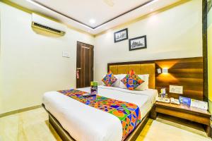 a hotel room with a large bed and a desk at FabHotel Ascot International II in Mumbai