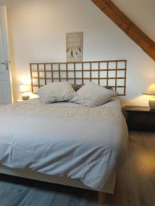 a bedroom with a large white bed with two pillows at Le pâtureau d'en haut in Gièvres