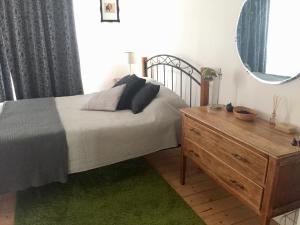 a bedroom with a bed and a mirror and a dresser at Black Cat Retreat holiday home in Nildottie