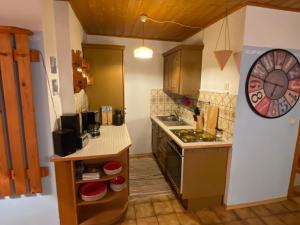 a small kitchen with a counter and a clock on the wall at Gartenwohnung im Gut Sonnenwald in Schöllnach