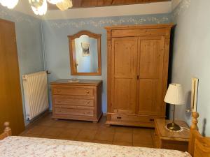 a bedroom with a bed and a dresser and a mirror at Gartenwohnung im Gut Sonnenwald in Schöllnach