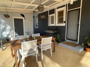 a wooden table and chairs on a patio at Black Cat Retreat holiday home in Nildottie