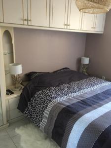 a bed with a black and white comforter in a bedroom at MAZET DE LA MER 54M2 LAVANDOU 100M PLAGE avec PISCINE in Le Lavandou +16 photos