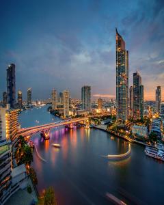 une ligne d'horizon nocturne avec une rivière et un pont dans l'établissement Shangri-La Bangkok, à Bangkok