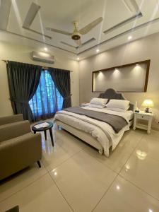 ein Schlafzimmer mit einem großen Bett und einem Sofa in der Unterkunft Luxury Guest House in Bahria Town in Rawalpindi