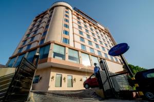 a tall building with a man standing in front of it at Sarovar Portico Jaipur in Jaipur
