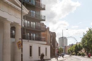 a man walking down a street next to a building at London Serviced Apartments in London