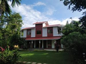 a red and white house with a yard at Peaceful Chaitra Villa 5Bhk And 4Bhk Alibaug Swimming Pool Is Common Between Both Property in Alibaug