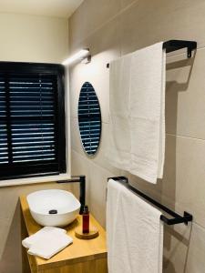 a bathroom with a white sink and towels at Vakantievilla Leonie in Lo-Reninge