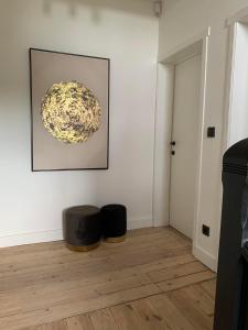 a room with a white wall with a picture and two stools at Vakantievilla Leonie in Lo-Reninge