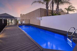 a swimming pool on a deck next to a house at Deco Beach Luxury Apartments in Port Lincoln