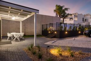 a patio with a table and chairs and a building at Deco Beach Luxury Apartments in Port Lincoln