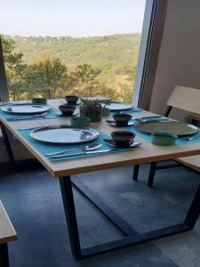 a table with plates and bowls on top of it at BluSalzz Escapade, Lansdowne - Uttarakhand in Lansdowne