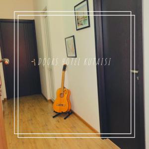 a guitar sitting in a room next to a door at Doors in Kutaisi