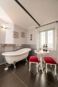 a bathroom with a tub and a table and two stools at Lange in Priocca