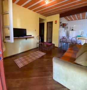 un salon avec un canapé et une salle à manger dans l'établissement Casa das mandalas Lavras Novas, à Lavras Novas