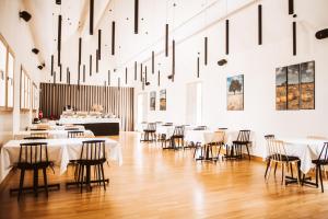 a dining room with tables and chairs and chandeliers at Dvorac Janković in Suhopolje
