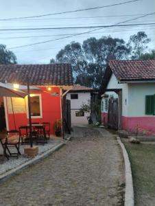a group of houses with a table and chairs at Casa das mandalas Lavras Novas in Lavras Novas