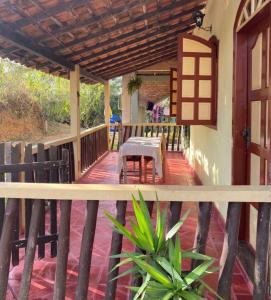 une terrasse couverte d'une maison avec une table et des chaises dans l'établissement Casa das mandalas Lavras Novas, à Lavras Novas