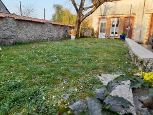 a yard with a tree and a building at Gîte les Fred’s in Cormery