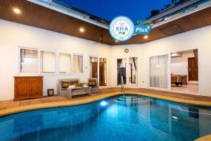 Village Austria Luxury Pool Villas في جنوب باتايا: مسبح في غرفة الفندق مع مسبح