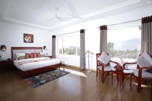 een slaapkamer met een bed en een tafel en stoelen bij The Zen Ladakh in Leh